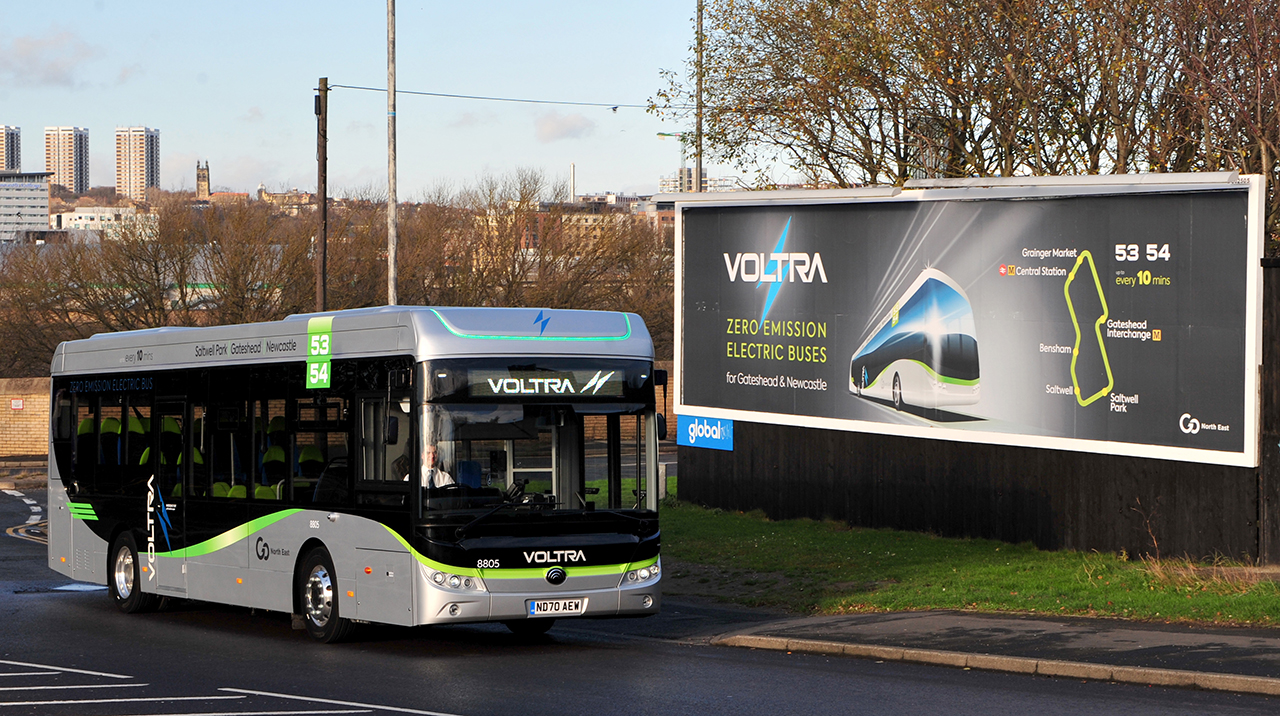 Voltra bus with advertising billboard in background